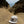 White cap with a logo on a sandy beach with ocean and cliffs in the background